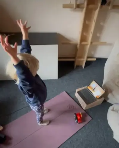 Ein Kind streckt die Arme weit nach oben
